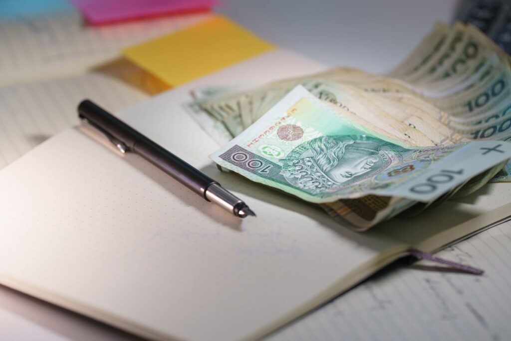 Close-up of Polish Zloty banknotes on an open notebook with a pen, symbolizing finance and budgeting