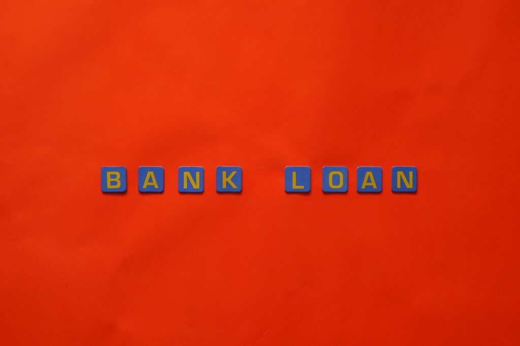 Letters forming 'Bank Loan' on a vibrant red surface, ideal for finance themes.